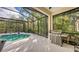 Covered patio with pool, built-in grill, and lush landscaping at 7275 Lismore Ct, Lakewood Ranch, FL 34202