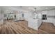 Open concept kitchen with white cabinets, large island with waterfall countertop, and stainless steel appliances at 353 Suwanee Ave, Sarasota, FL 34243