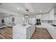 Modern kitchen featuring white cabinets, a large island, and a stylish light fixture at 353 Suwanee Ave, Sarasota, FL 34243