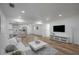 Open living room showcasing hardwood floors, white couch, and a large TV at 353 Suwanee Ave, Sarasota, FL 34243