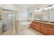 Elegant bathroom with a soaking tub, walk-in shower, and double vanity at 13215 Ramblewood Trl, Bradenton, FL 34211