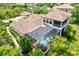 Stunning aerial view of a tile roof home with a screened-in pool and lush landscaping at 13215 Palmers Creek Ter, Lakewood Ranch, FL 34202