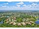 Aerial view of a community near a golf course with mature trees and scenic lakes at 13215 Palmers Creek Ter, Lakewood Ranch, FL 34202
