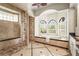 Luxurious bathroom featuring a soaking tub with arched windows, a spacious shower, and elegant tile work at 13215 Palmers Creek Ter, Lakewood Ranch, FL 34202