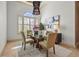 Bright dining area featuring a glass table, contemporary light fixture, and window with plantation shutters at 13215 Palmers Creek Ter, Lakewood Ranch, FL 34202