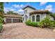 Stunning exterior of a Mediterranean-style home with a tile roof, arched windows, and a lushly landscaped yard at 13215 Palmers Creek Ter, Lakewood Ranch, FL 34202