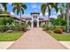 Stunning Mediterranean-style home with lush landscaping, terracotta roof, and paver driveway at 13215 Palmers Creek Ter, Lakewood Ranch, FL 34202