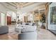 Spacious living room featuring a large chandelier, columns, neutral furnishings, and access to other living spaces at 13215 Palmers Creek Ter, Lakewood Ranch, FL 34202
