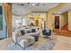 Open living space with a sofa, hardwood floors, and seamlessly connects to a kitchen with a breakfast bar at 13215 Palmers Creek Ter, Lakewood Ranch, FL 34202