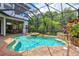 Inviting screened-in pool and spa area featuring a rock waterfall and a covered patio at 13215 Palmers Creek Ter, Lakewood Ranch, FL 34202