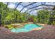 A beautiful screened-in pool and spa area surrounded by lush landscaping and brick pavers at 13215 Palmers Creek Ter, Lakewood Ranch, FL 34202