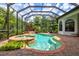 Beautiful screened-in pool and spa area surrounded by lush landscaping and brick pavers at 13215 Palmers Creek Ter, Lakewood Ranch, FL 34202