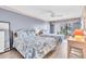 Bright bedroom with two beds featuring decorative linens, complemented by wicker furnishings and water views from the balcony at 1602 Stickney Point Rd # 305, Sarasota, FL 34231