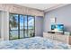 Bedroom with sliding glass doors out to a lanai with a palm tree view and water views at 1602 Stickney Point Rd # 305, Sarasota, FL 34231