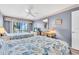 Bedroom with two beds and wicker furniture with a view of the water and palm trees beyond the sliding glass doors at 1602 Stickney Point Rd # 305, Sarasota, FL 34231