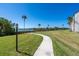 Curving sidewalk and manicured grounds with lake views and mature trees at 1602 Stickney Point Rd # 305, Sarasota, FL 34231