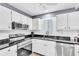 Kitchen with stainless steel appliances, tile backsplash and granite countertops at 1602 Stickney Point Rd # 305, Sarasota, FL 34231