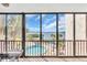 Lanai with floor to ceiling glass panels providing views of the pool, waterfront, blue sky, and palm trees at 1602 Stickney Point Rd # 305, Sarasota, FL 34231