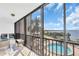 Lanai with floor to ceiling windows showcasing waterfront views, a pool, and palm trees at 1602 Stickney Point Rd # 305, Sarasota, FL 34231