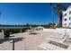 Community patio features lounge chairs and tables overlooking waterfront view at 1602 Stickney Point Rd # 305, Sarasota, FL 34231