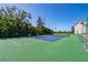 Community tennis court surrounded by lush landscaping and palm trees at 1602 Stickney Point Rd # 305, Sarasota, FL 34231