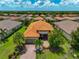 Aerial view showcases a beautiful home with a well-manicured lawn, and a screened-in patio with a tile roof at 5010 Tivoli Run, Bradenton, FL 34211