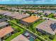 Aerial view of a home featuring a screened patio, set within a well-maintained community with lush landscaping and a nearby lake at 5010 Tivoli Run, Bradenton, FL 34211