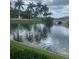 Serene lakefront view with lush landscaping and palm trees at 177 Vinadio Blvd, Nokomis, FL 34275