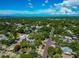 Aerial view of a neighborhood with houses, tree canopies, and a glimpse of the ocean at 150 21St S Ave, St Petersburg, FL 33705