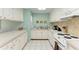 Well-equipped kitchen with white cabinets and tile countertops at 6157 Midnight Pass Rd # C12, Sarasota, FL 34242