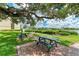 Community picnic area with tables under a large shade tree at 6157 Midnight Pass Rd # C12, Sarasota, FL 34242