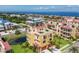 Stunning coastal home featuring a red tile roof, lush landscaping, and expansive ocean views from a rooftop terrace at 1450 Silvia Shores Dr, Apollo Beach, FL 33572