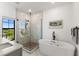 Bright bathroom featuring a marble tiled shower, luxurious soaking tub, and an abundance of natural light at 1450 Silvia Shores Dr, Apollo Beach, FL 33572