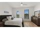 Comfortable bedroom with a ceiling fan, dresser, and many windows at 1450 Silvia Shores Dr, Apollo Beach, FL 33572