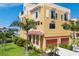 Elegant, multi-story condo building featuring a 2-car garage, lush landscaping, and beautiful architecture at 1450 Silvia Shores Dr, Apollo Beach, FL 33572