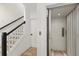 Bright hallway featuring an elevator, stairs with dark railings, and neutral decor at 1450 Silvia Shores Dr, Apollo Beach, FL 33572