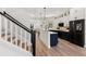 Modern kitchen and staircase with light wood floors and dark hardware and accents at 1450 Silvia Shores Dr, Apollo Beach, FL 33572