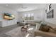 Bright living room featuring stylish sectional sofa, light gray wood floors, and modern decor at 1450 Silvia Shores Dr, Apollo Beach, FL 33572