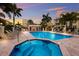Beautiful community pool and hot tub surrounded by lounge chairs and palm trees at sunset at 1450 Silvia Shores Dr, Apollo Beach, FL 33572