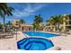 Community pool with lounge chairs, a spa, and lush landscaping surrounding it at 1450 Silvia Shores Dr, Apollo Beach, FL 33572