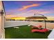 Relaxing rooftop terrace featuring a lounge area with sun loungers, an umbrella, and synthetic grass at 1450 Silvia Shores Dr, Apollo Beach, FL 33572