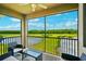 Enjoy the view of the lake and golf course from the screened-in balcony with comfortable seating area at 17704 Gawthrop Dr # 402, Bradenton, FL 34211