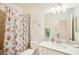 Bathroom with shower, colorful curtain, white vanity and mirror at 17704 Gawthrop Dr # 402, Bradenton, FL 34211