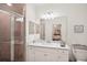 Bathroom view with a glass shower door, white vanity, coordinated decor, and a large mirror at 17704 Gawthrop Dr # 402, Bradenton, FL 34211