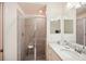 Bathroom view with a glass shower door, white vanity, coordinated decor, and a large mirror at 17704 Gawthrop Dr # 402, Bradenton, FL 34211