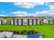 Scenic view of a well-maintained condo building with spacious balconies, surrounded by lush greenery and a tranquil pond at 17704 Gawthrop Dr # 402, Bradenton, FL 34211