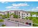 Exterior view of a multi-story condo building with carports, palm trees, and nearby water features at 17704 Gawthrop Dr # 402, Bradenton, FL 34211