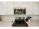 Modern kitchen featuring stainless steel appliances, white cabinetry, and sleek countertops at 17704 Gawthrop Dr # 402, Bradenton, FL 34211