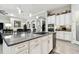 Open concept kitchen with a gray countertop island, stainless steel appliances, and views of the dining area at 5802 Alabaster Stone Ln, Apollo Beach, FL 33572