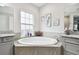 Relaxing bathroom with a large soaking tub and granite vanity at 5802 Alabaster Stone Ln, Apollo Beach, FL 33572